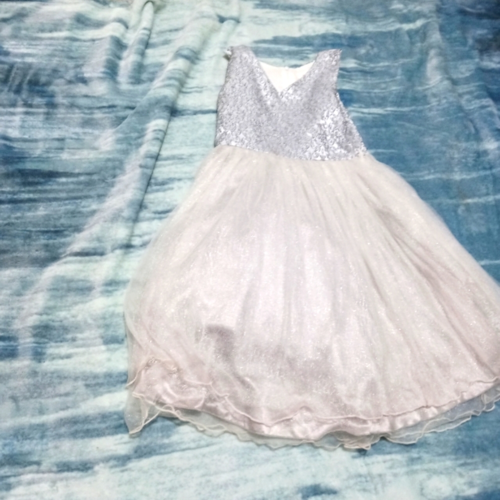 It is a silver dress with designs on the top
